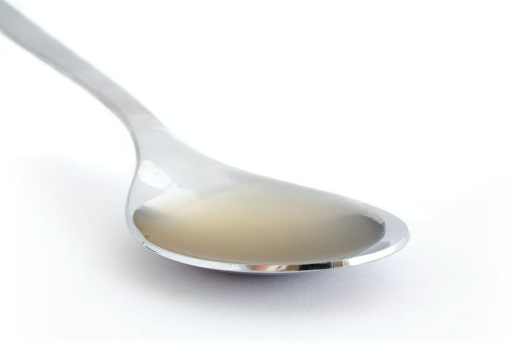 Spoon of raw unfiltered apple cider vinegar with &#8220;mother&#8221;.
