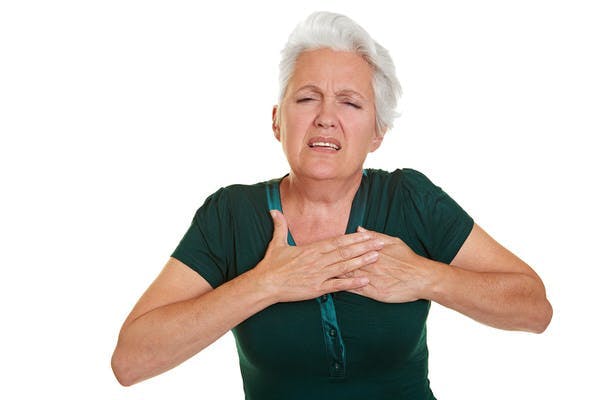 Senior woman having coronary and holding hand to her chest
