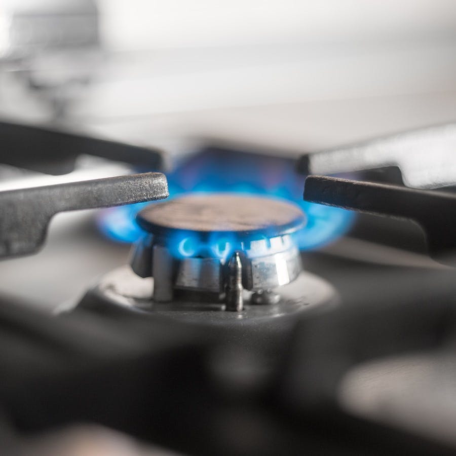 Blue flames of gas burning from a kitchen gas stove. Shallow DOF, selective focus.
