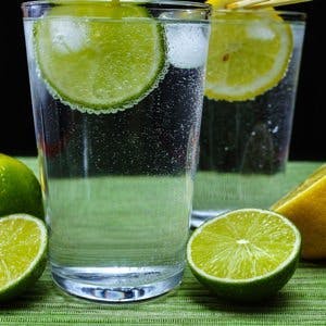 Glass with cold sparkling mineral water lime and lemon seltzer
