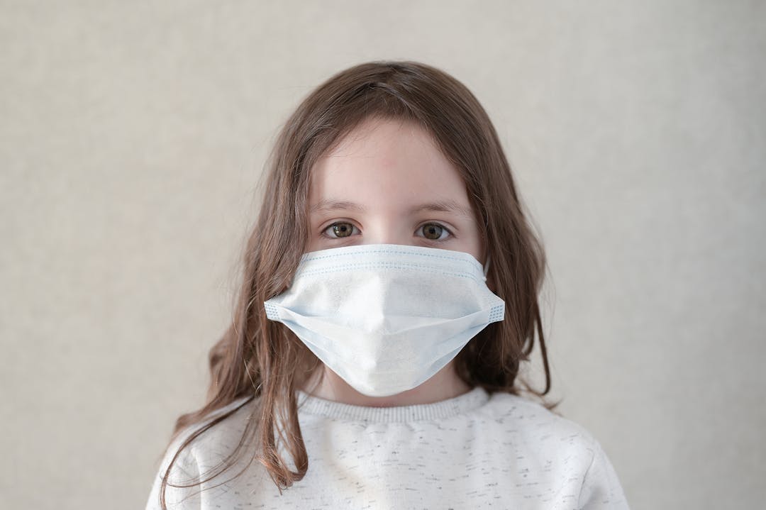 Coronavirus COVID-19 epidemic outbreak quarantine concept of cute little girl wearing protection medical mask
