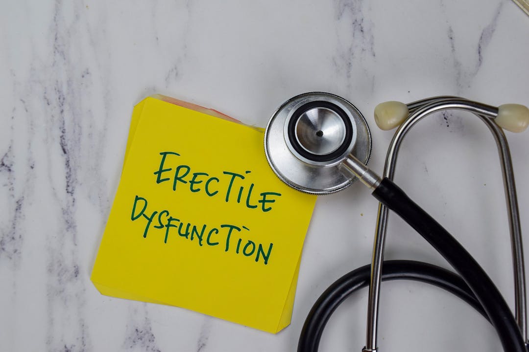 Erectile Dysfunction write on sticky notes isolated on Wooden Table.
