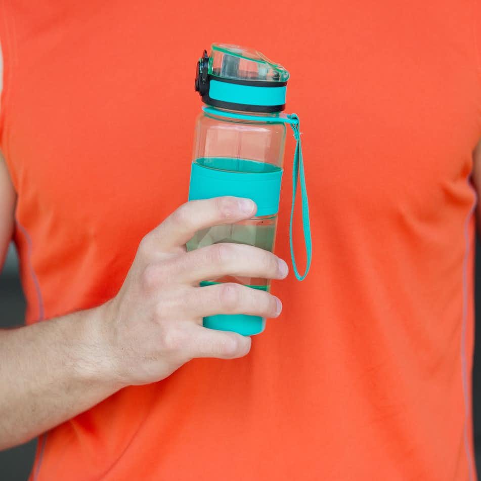 Man holding a plastic water bottle made with BPA substitutes